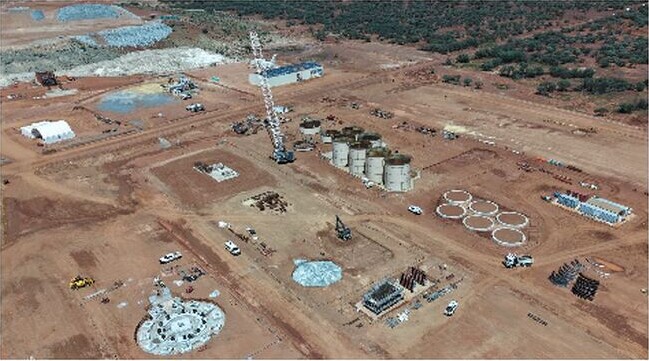 Aerial photograph of earthworks, cranes, circular tank footings and equipment at the Youanmi processing plant construction site.