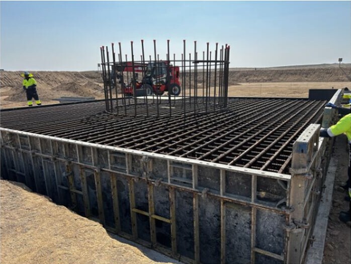Construction workers beside steel reinforcement and shuttering prepared for a concrete pour at the Tumas project.